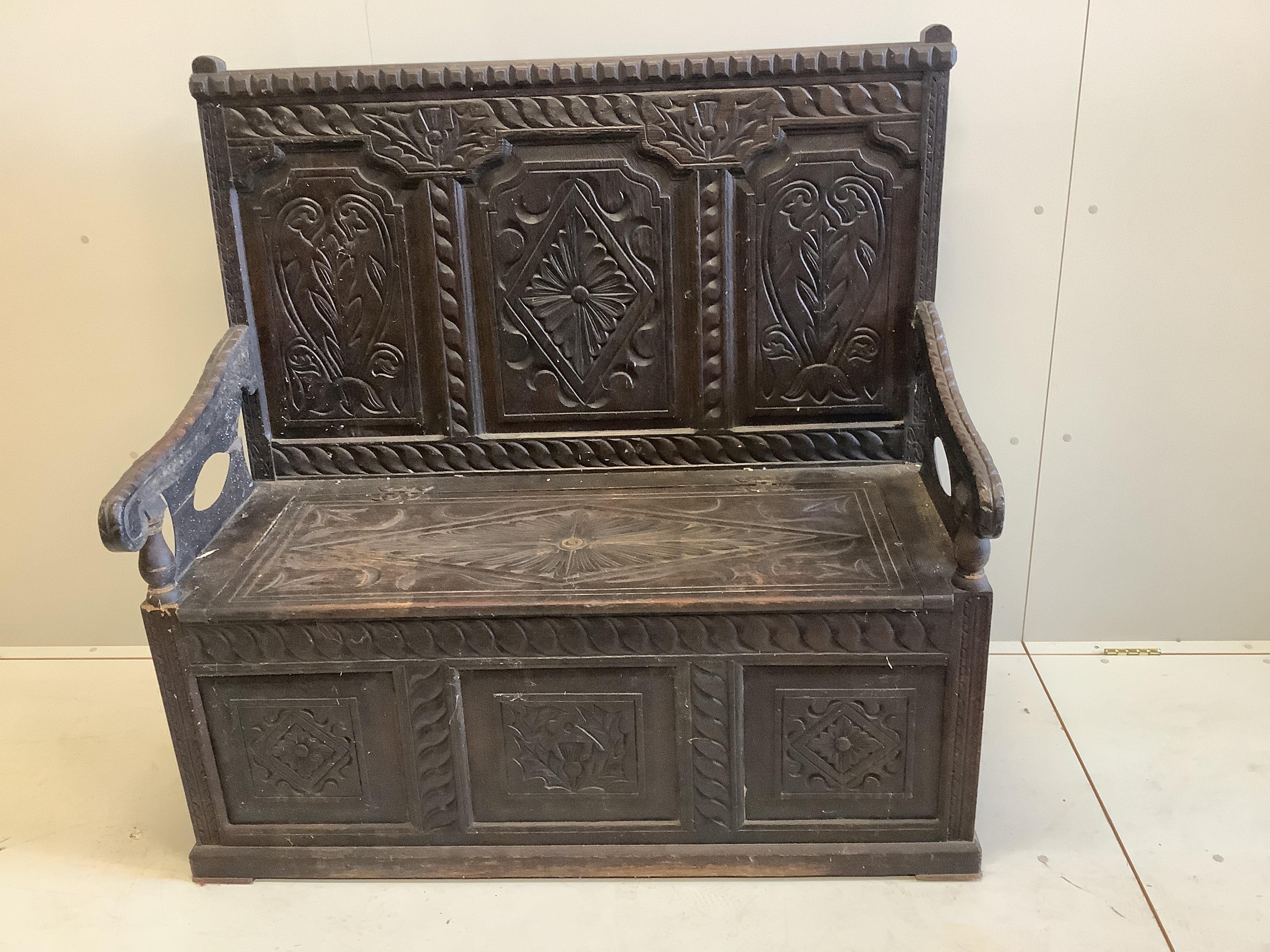 An early 20th century carved oak box seat settle, width 122cm, depth 56cm, height 121cm